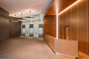 Photo d'architecture intérieur du lobby du 1100 Atwater à Montréal, montrant le bureau de la réception et les ascenseurs à l'arrière plan