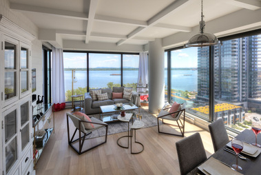 Salon dans un condo à l'Ile des Soeurs à Montréal, on y voit le divant et aussi une partie de la salle à manger et la vue du fleuve St-Laurent à l'arrière plan