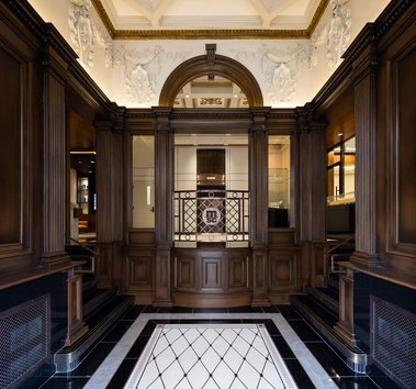 Hall d'entrée du 7 rue St-Jacques à Montréal, avec ses grandes portes, ses boiseries et son plancher de marbre blanc