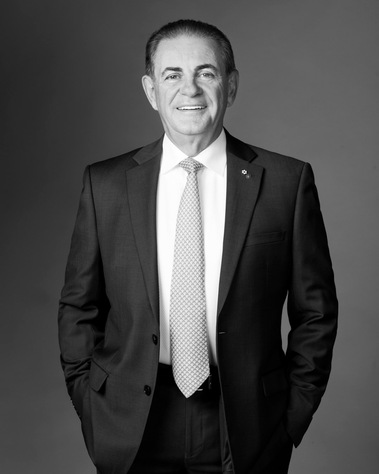 Portrait corporatif en plan américain de M. Jacques Duchesneau, en veston cravate, souriant en noir et blanc