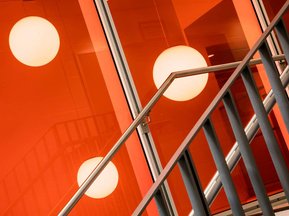 Photo  d'un escalier dans une école de Montréal avec rampes métalliques et luminaires suspendus en arrière plan