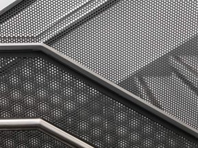 Photo noir et blanc d'un escalier au rampes en acier dans une école de Montréal