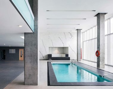 Piscine intérieure avec grandes fenêtreset murs de marbre