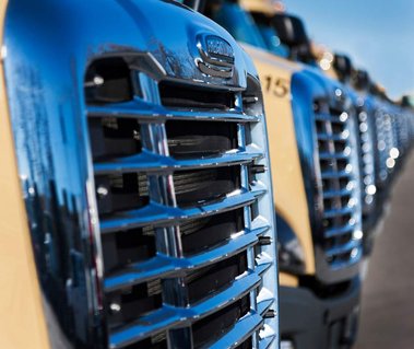 Calandre de camions alignés côte à côte dans un terrain de stationnement