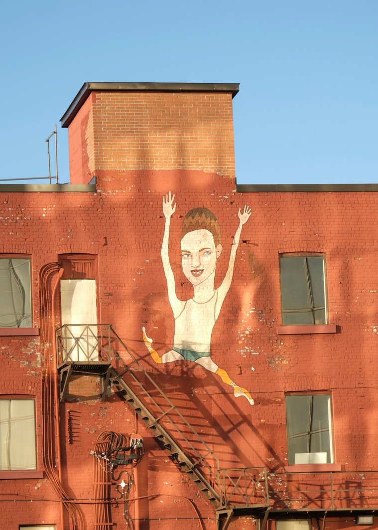 Art mural of a caricature jumping down the stairs in Cedar St. Sudbury Ontario.