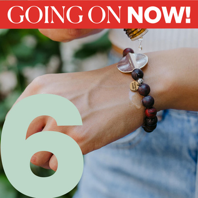 Woman dripping essential oil on bracelet with number 6 for the day of deal we are on plus a label stating - Going on Now!
