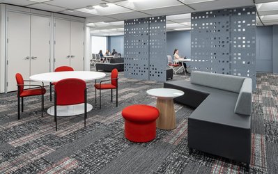 High-quality interior shot of a workplace breakout area with colorful modular seating, and flexible layouts designed for team interaction.