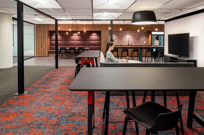 High-quality interior shot of a workplace breakout area with colorful modular seating, and flexible layouts designed for team interaction.