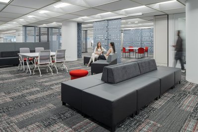 High-quality interior shot of a workplace breakout area with colorful modular seating, and flexible layouts designed for team interaction.