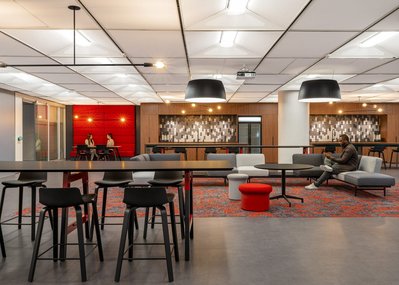 High-quality interior shot of a workplace breakout area with colorful modular seating, and flexible layouts designed for team interaction.