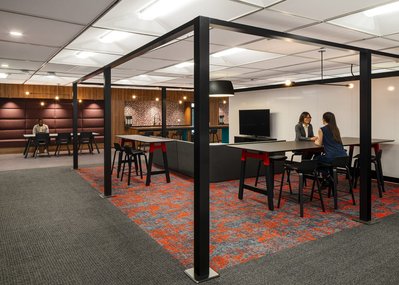High-quality interior shot of a workplace breakout area with colorful modular seating, and flexible layouts designed for team interaction.