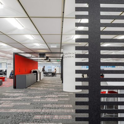 High-quality interior shot of a workplace breakout area with colorful modular seating, and flexible layouts designed for team interaction.