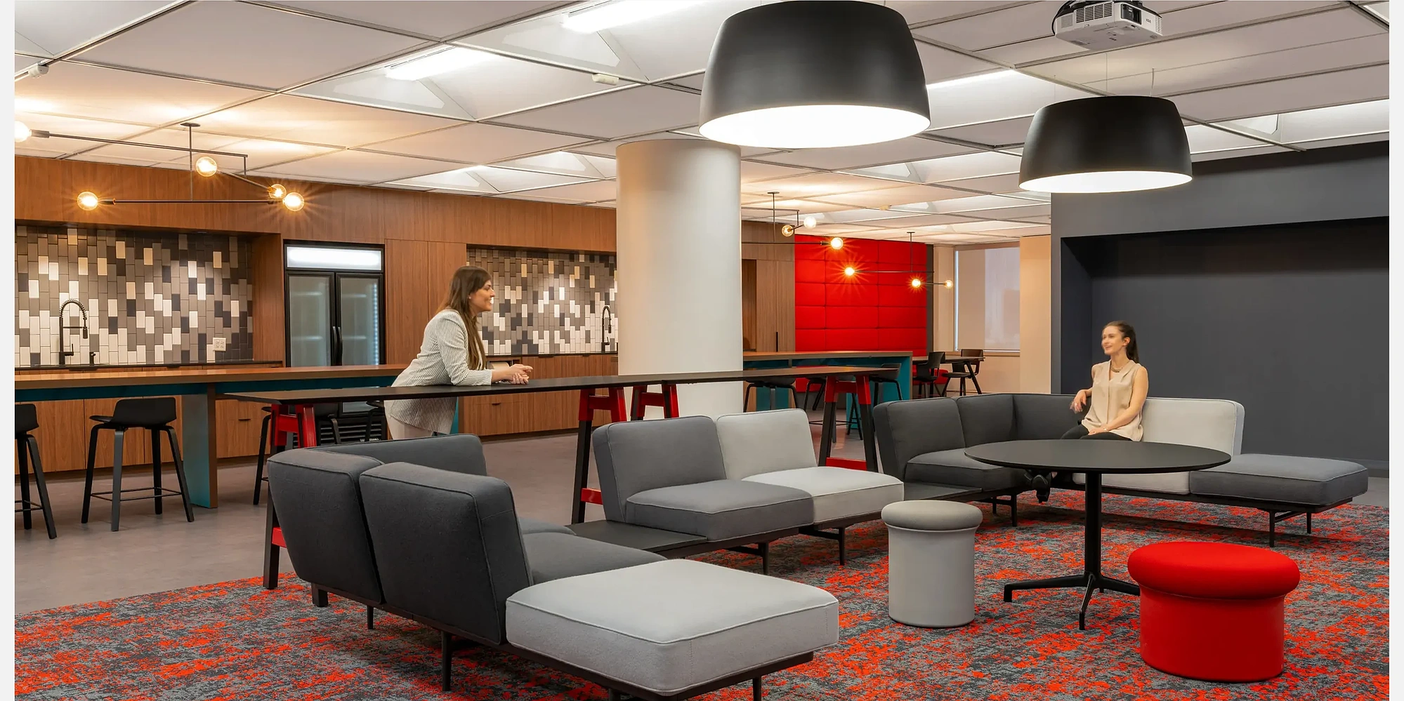 High-quality interior shot of a workplace breakout area with colorful modular seating, and flexible layouts designed for team interaction.
