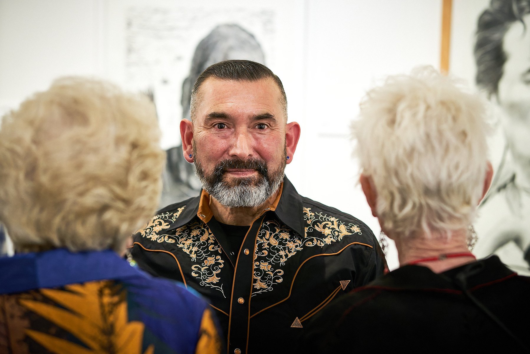Abel Alejandre speaks with patrons at his art opening at Muzeo in Anaheim, CA.