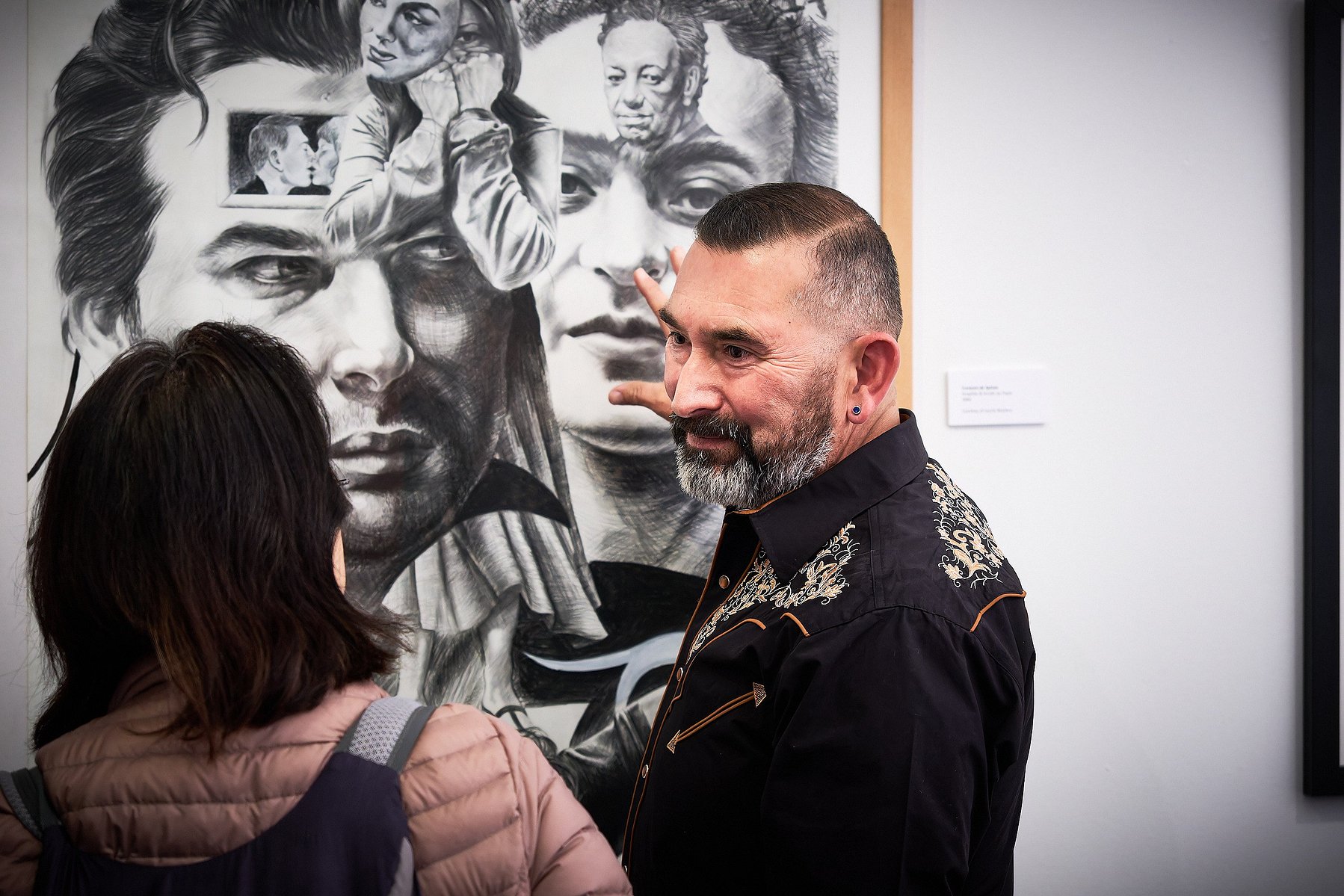 Abel Alejandre smiles and talks with a patron at his art opening Cuarenta at Muzeo, in Anaheim, CA.