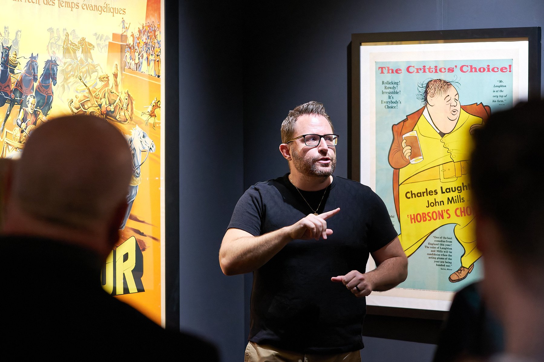 Clark Silva leads a group of VIP members through the gallery of "Painted for the Pictures" at Muzeo in Anaheim, CA