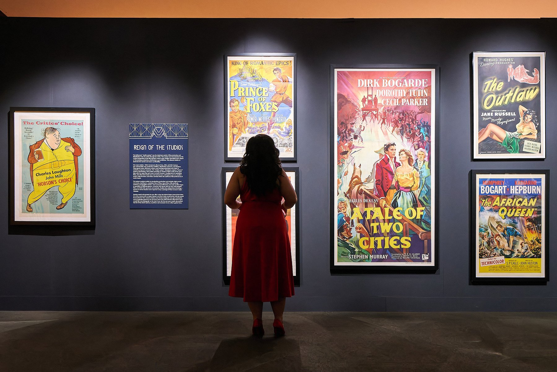 Silhouette of woman standing in front of classic movie posters at Muzeo in Anaheim, CA