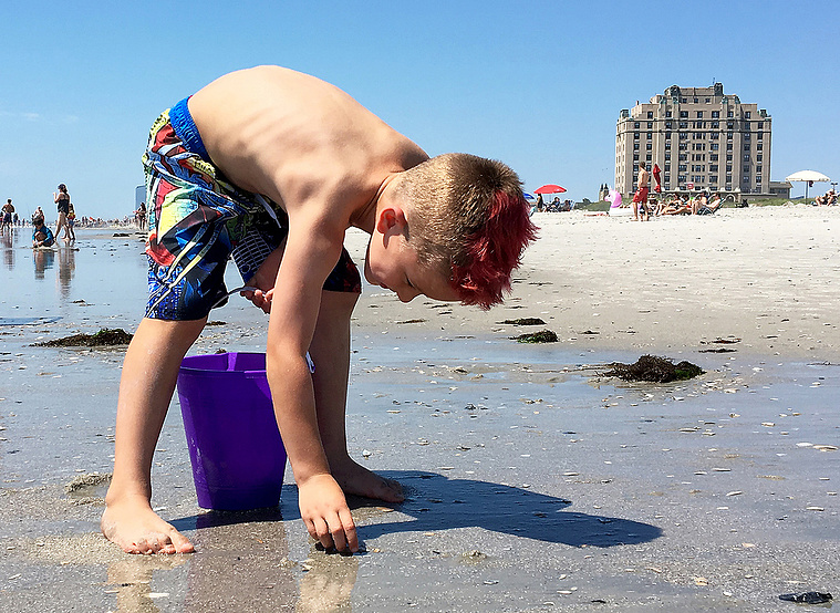 Boy collects shells in Brigantine, New Jersey, along the Jersey Shore.