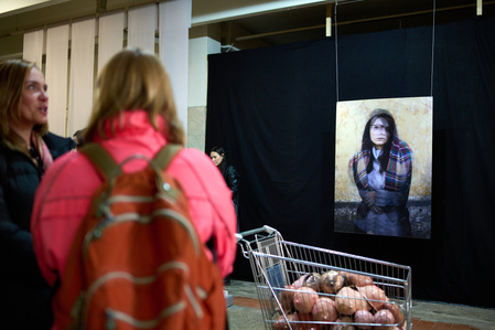 a shopping cart filled with women's breasts and a portrait photograph at an exhibition in Keskturg
