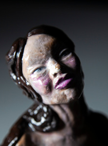 naked woman sculpture sitting on a glass vase made by European feminist artist Anrike Piel. 