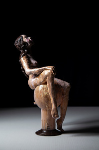 naked woman sculpture sitting on a glass vase made by European feminist artist Anrike Piel. 