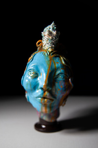A blue decorative vase and sculpture of a woman, portrait with seashell in hair