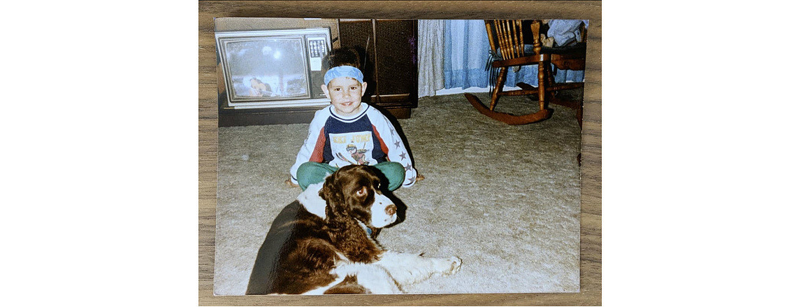 Small child sitting on floor with brown and white dog