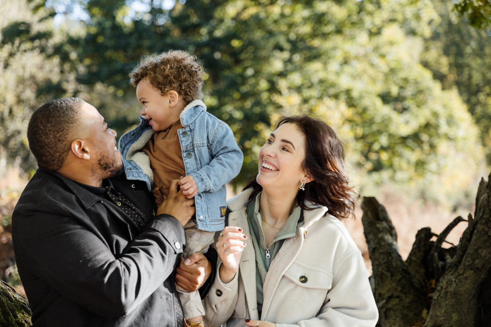 Three family members playing and laughing on a sunny day in Ashford in Kent having their photo taken on a family photo shoot by Katie Brown Photographer 