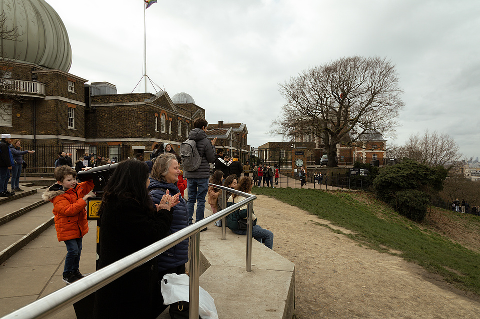 The crowd cheering at the royal observatory in Greenwich, London. They have just seen a successful proposal. 