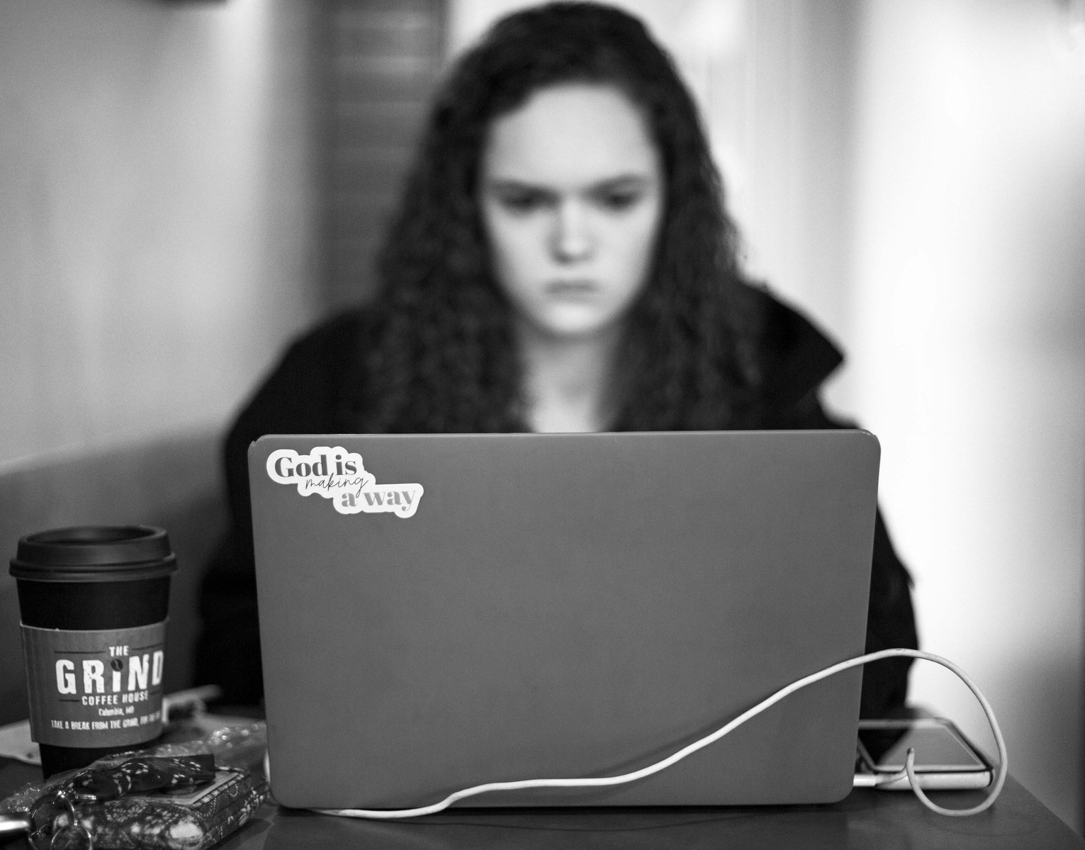 A women works on homework on her laptop in a coffee shop. (Kate Trabalka Photography)