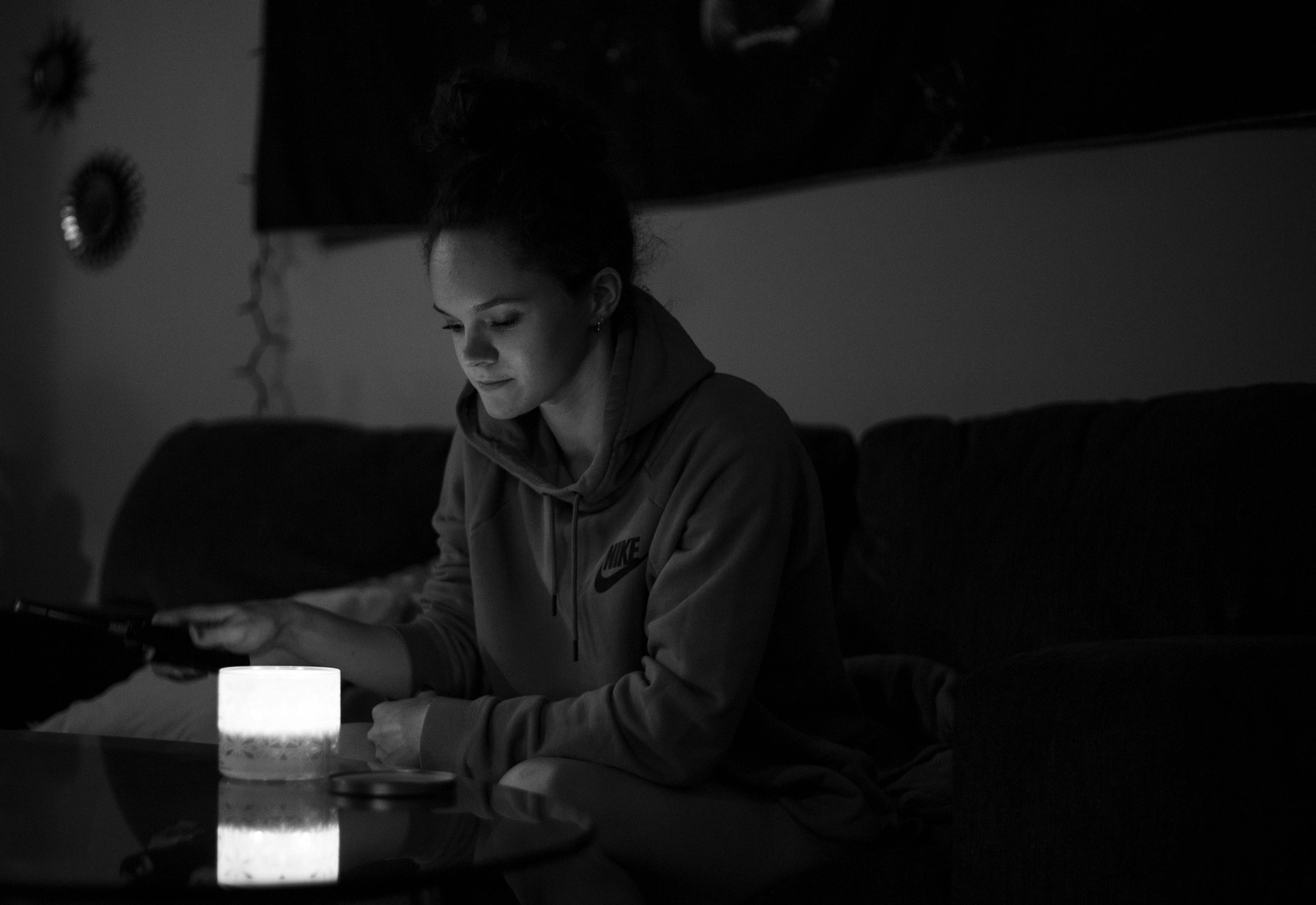 A women looks at candle she lit in her living room. (Kate Trabalka Photography)
