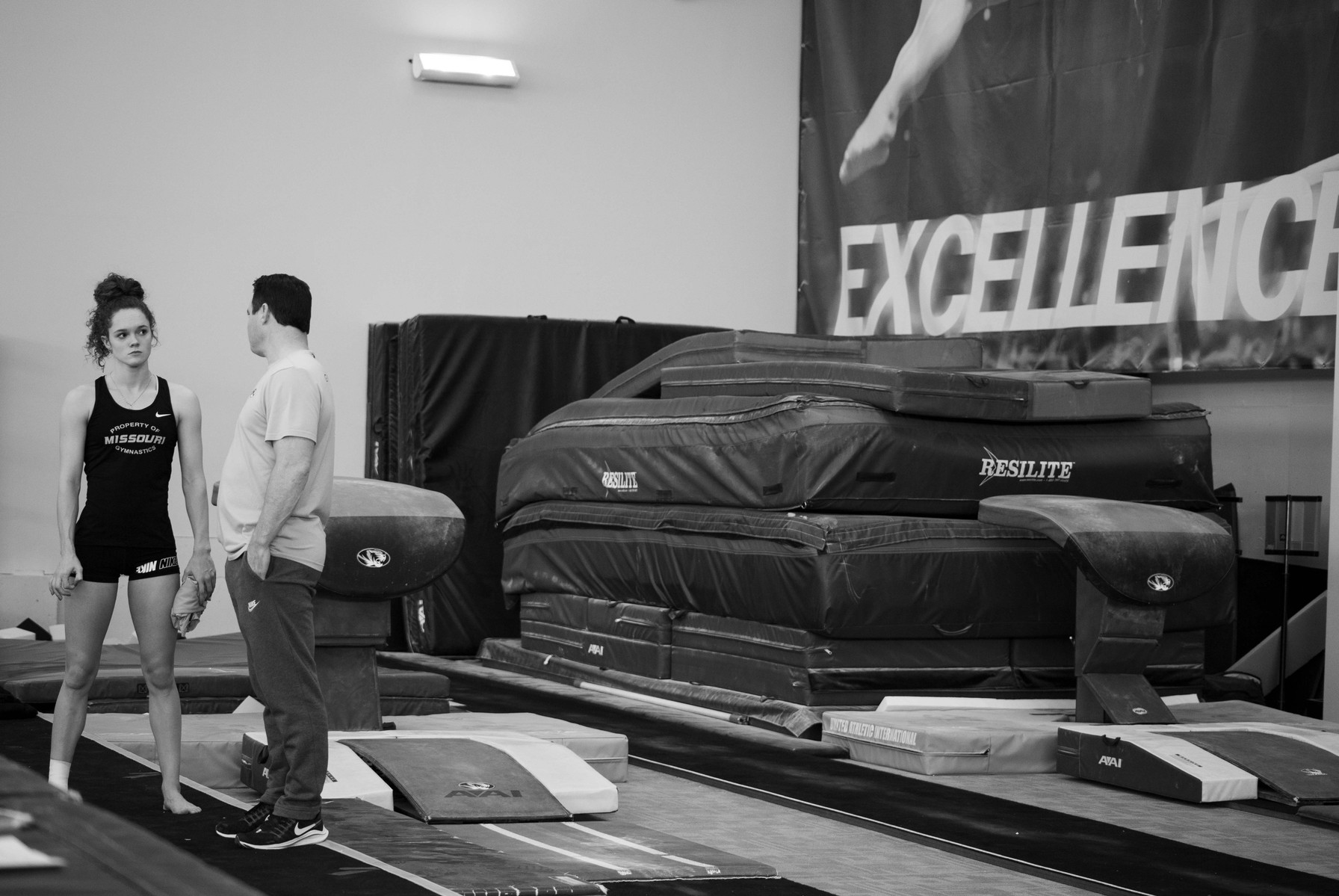A women gymnast talks to her coach during practice. (Kate Trabalka Photography)