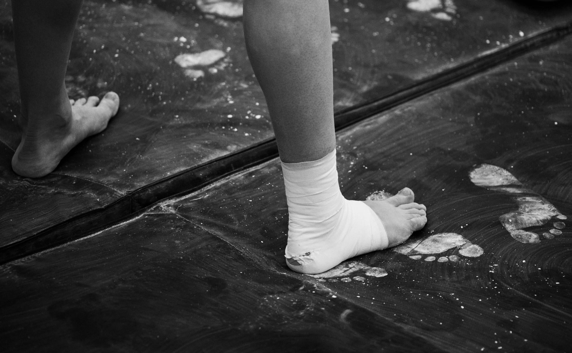 Wrapped feet stand on a mat covered in footprints. (Kate Trabalka Photography)