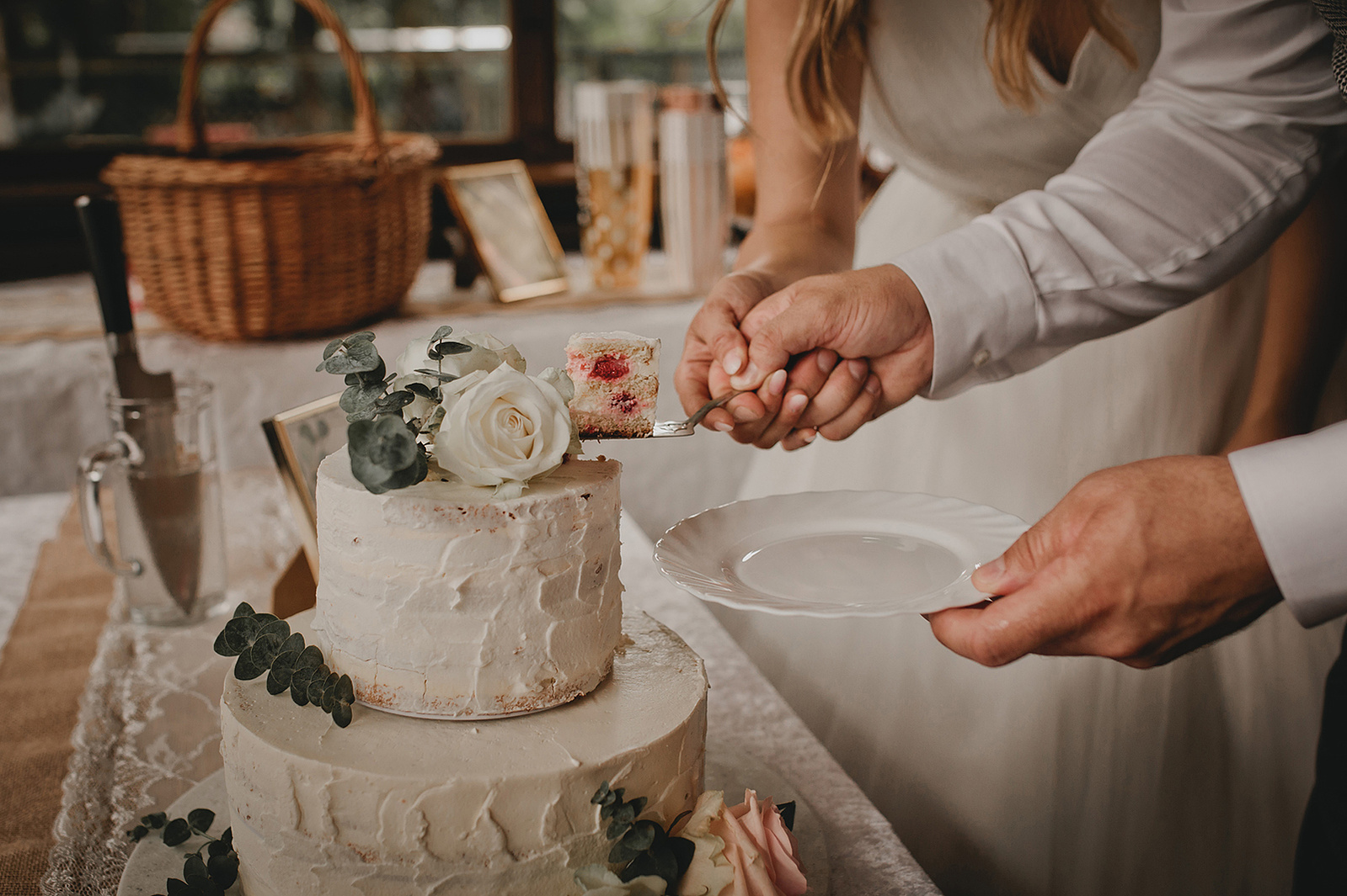 Brautpaar nimmt sich das erste Stück Hochzeitstorte bei der Hochzeitsfeier in Berlin