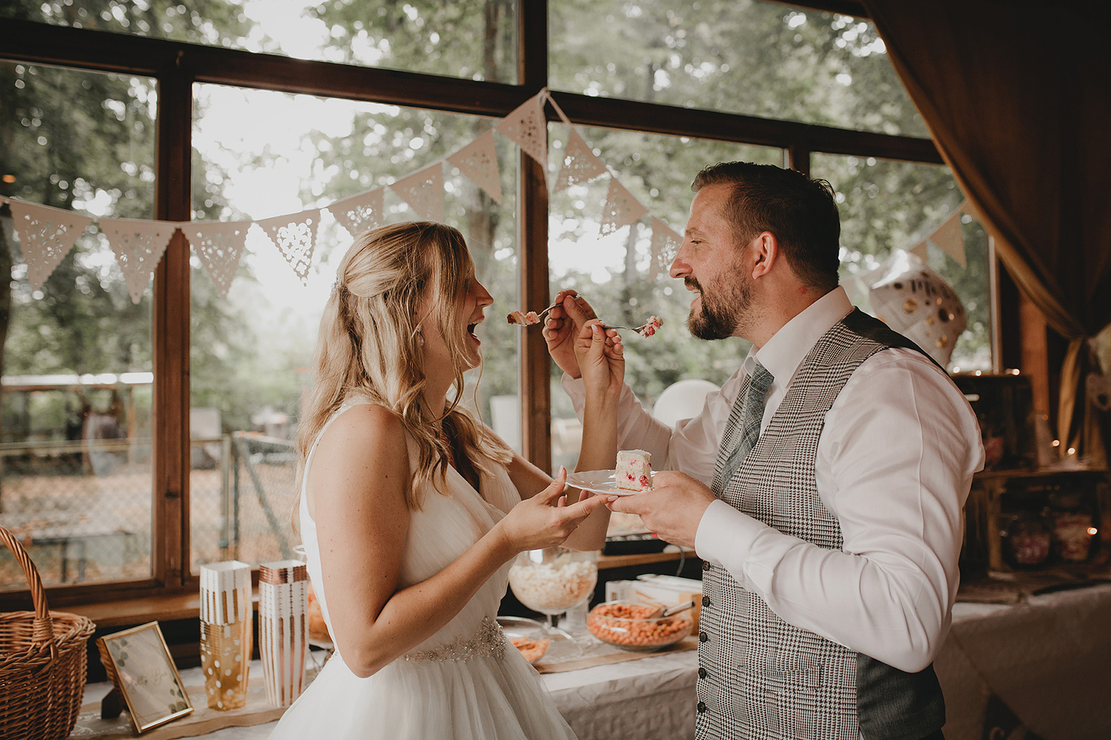 Braut und Bräutigam füttern sich gegenseitig mit der Hochzeitstorte