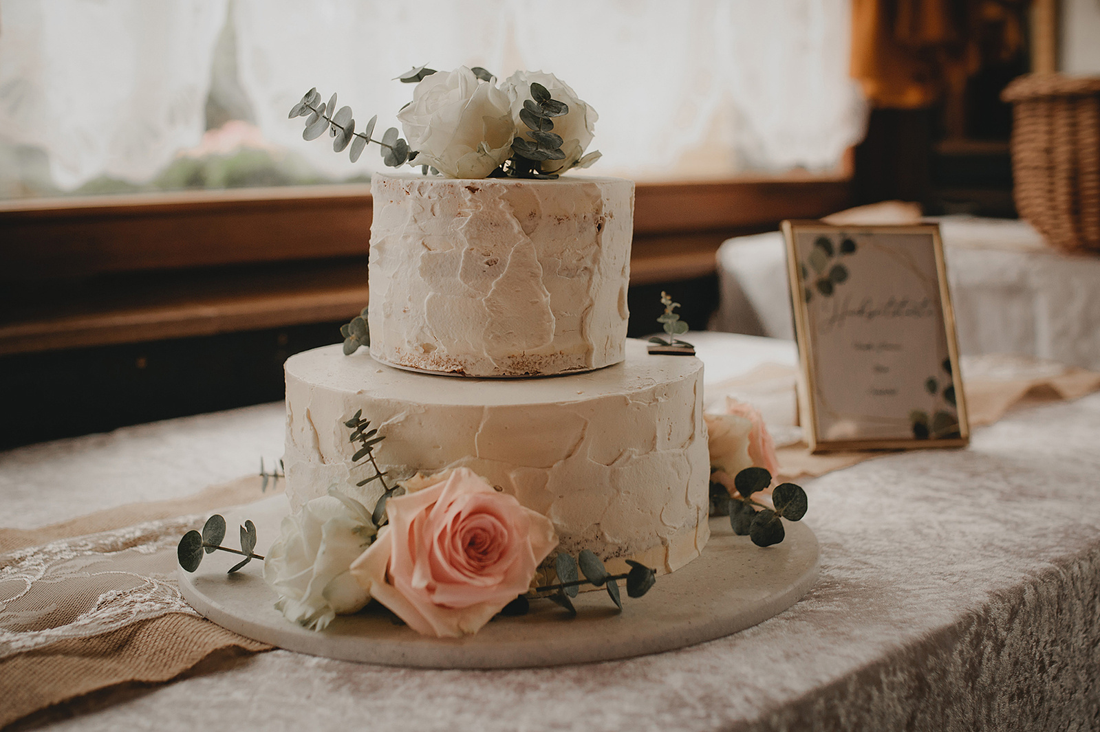 zweistöckige Hochzeitstorte als Naked Cake mit Rosen und Eukalyptus
