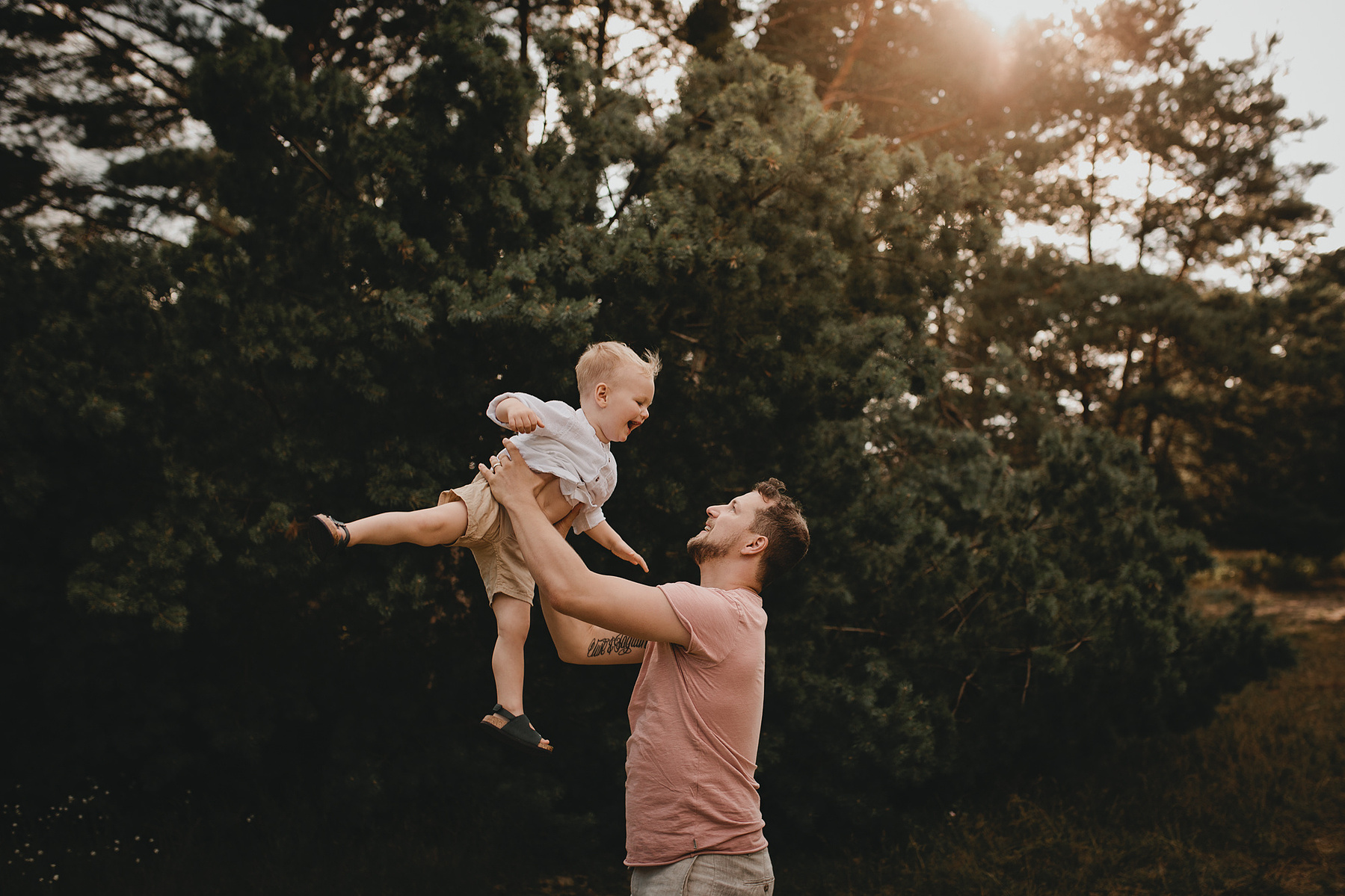 Chris wirft seinen Sohn beim Familienshooting in Berlin hoch in die Luft.