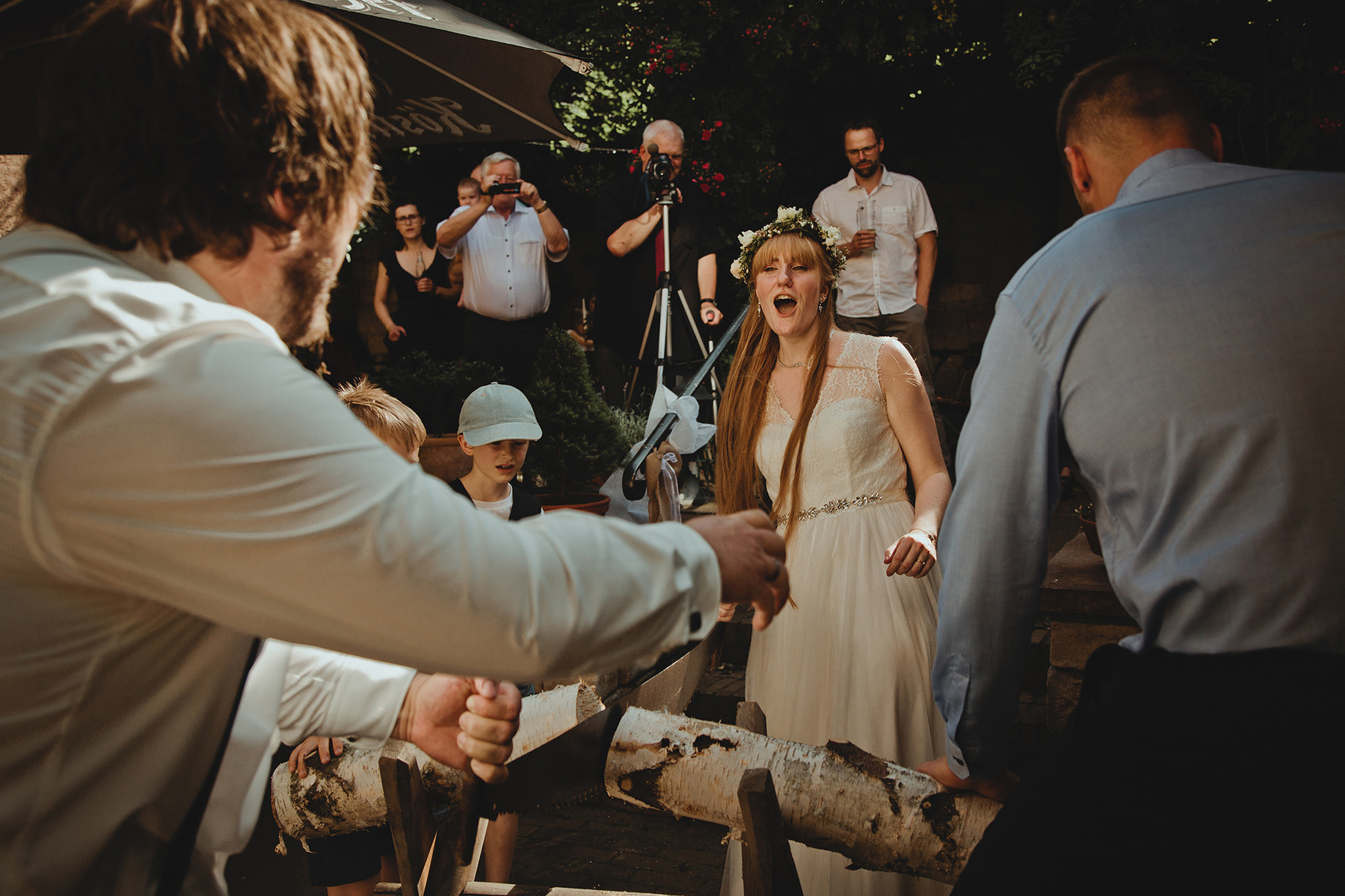 Die Braut jubelt nachdem der Baumstamm zersägt wurde. Ungestelltes Hochzeitsfoto von einer Fotografin in Weißenfels.