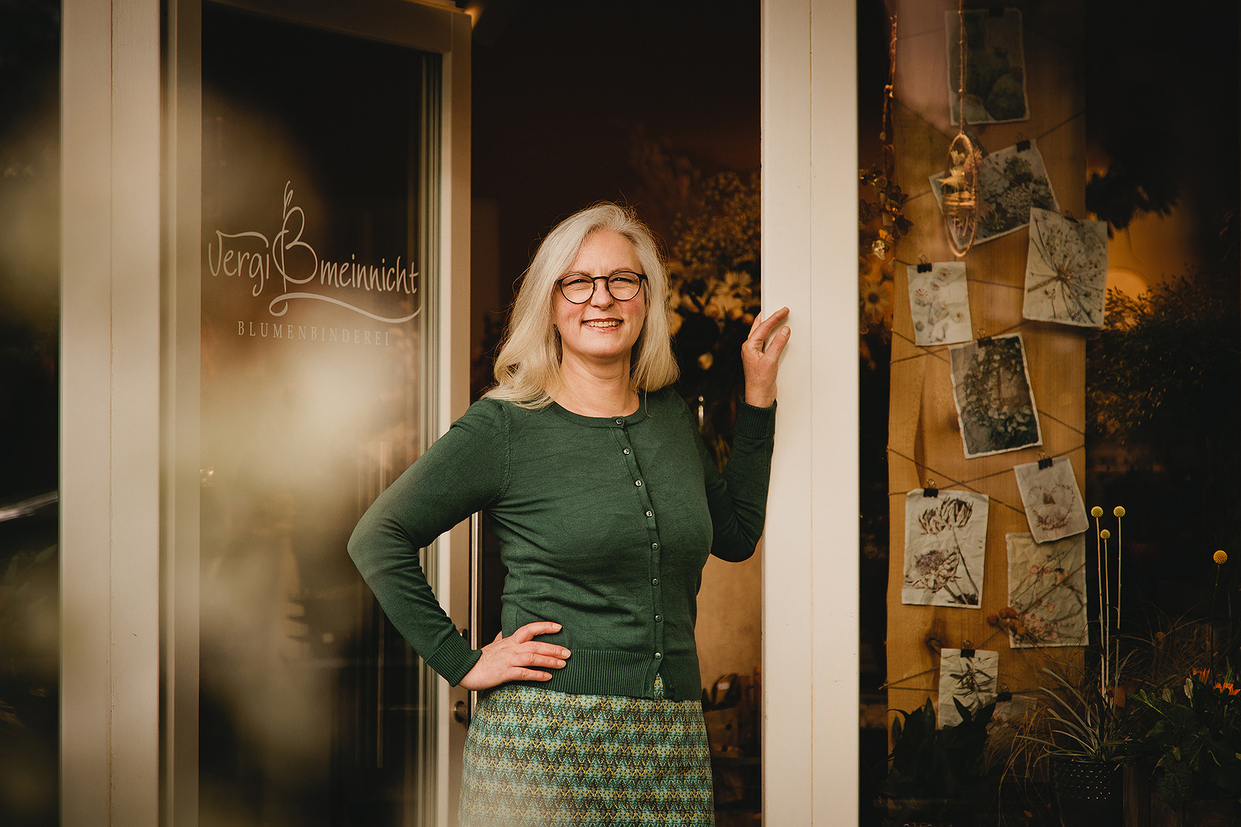 Eine Floristin steht in der Tür ihres Blumenladens während die Fotografin aus Berlin natürliche Businessportraits von ihr macht. 