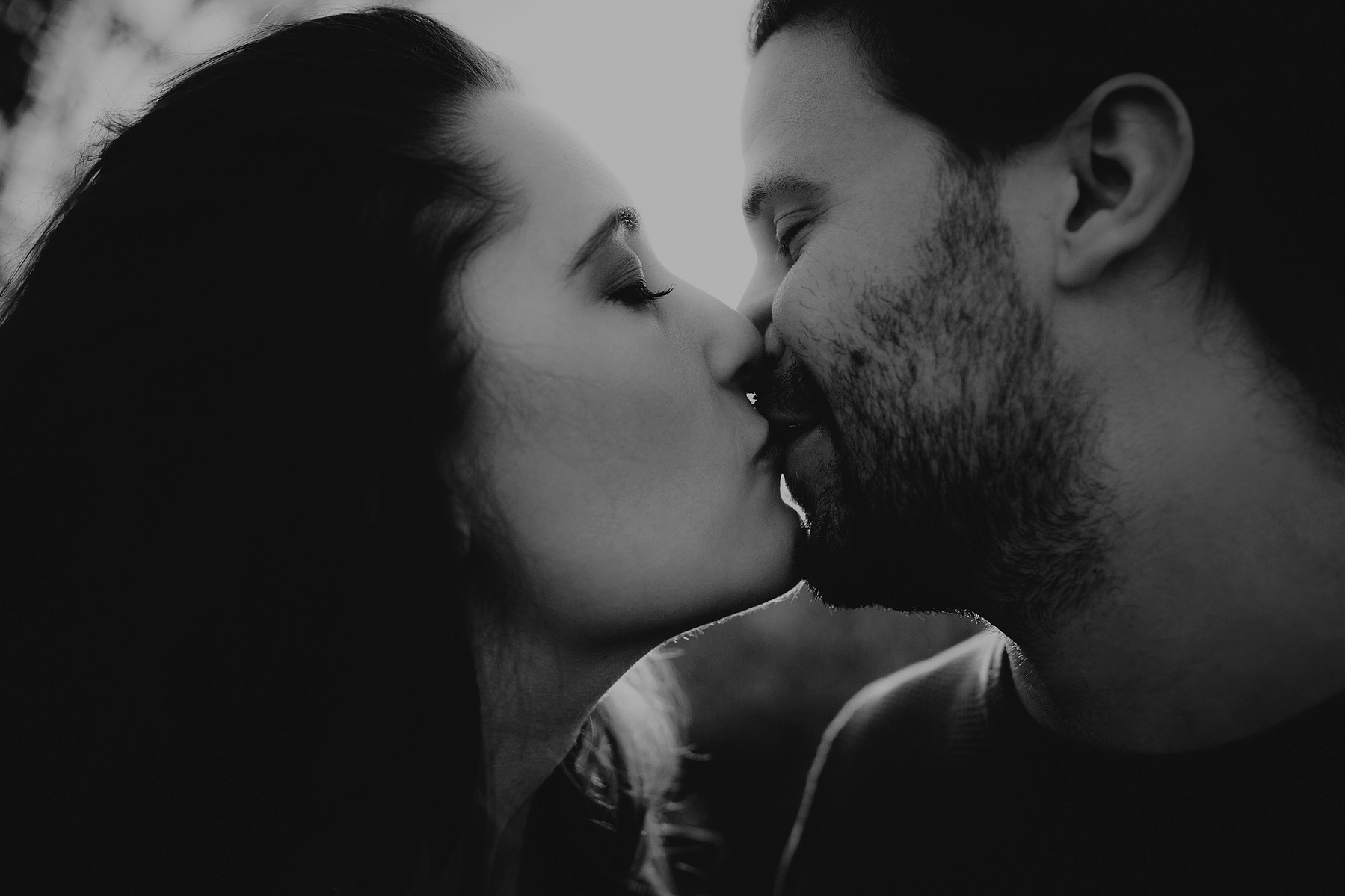 Inniger Moment während eines Couple Fotoshootings bei Berlin. Das Pärchen küsst sich zärtlich im Gegenlicht.