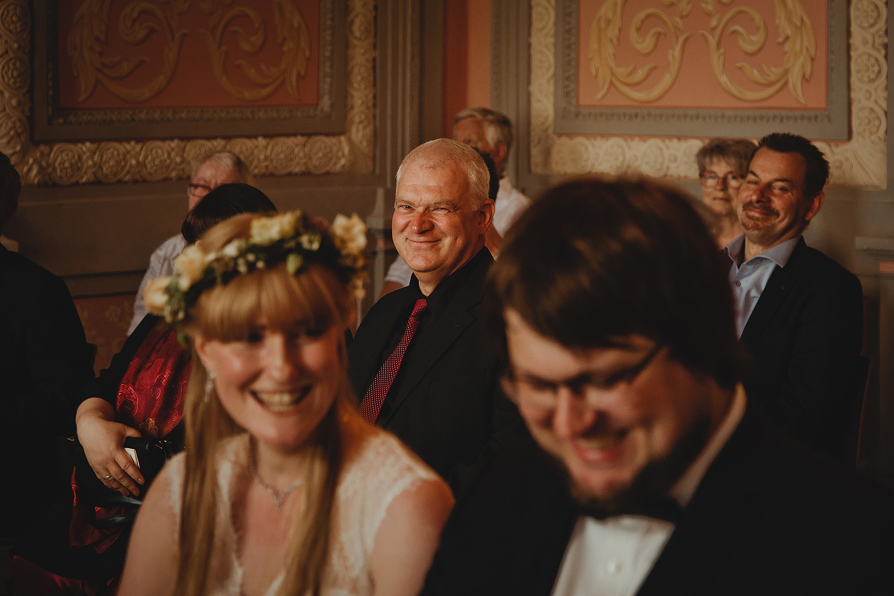 Der Brautvater blickt während der Trauung im Standesamt Weißenfels verschmitzt zur Hochzeitsfotografin.