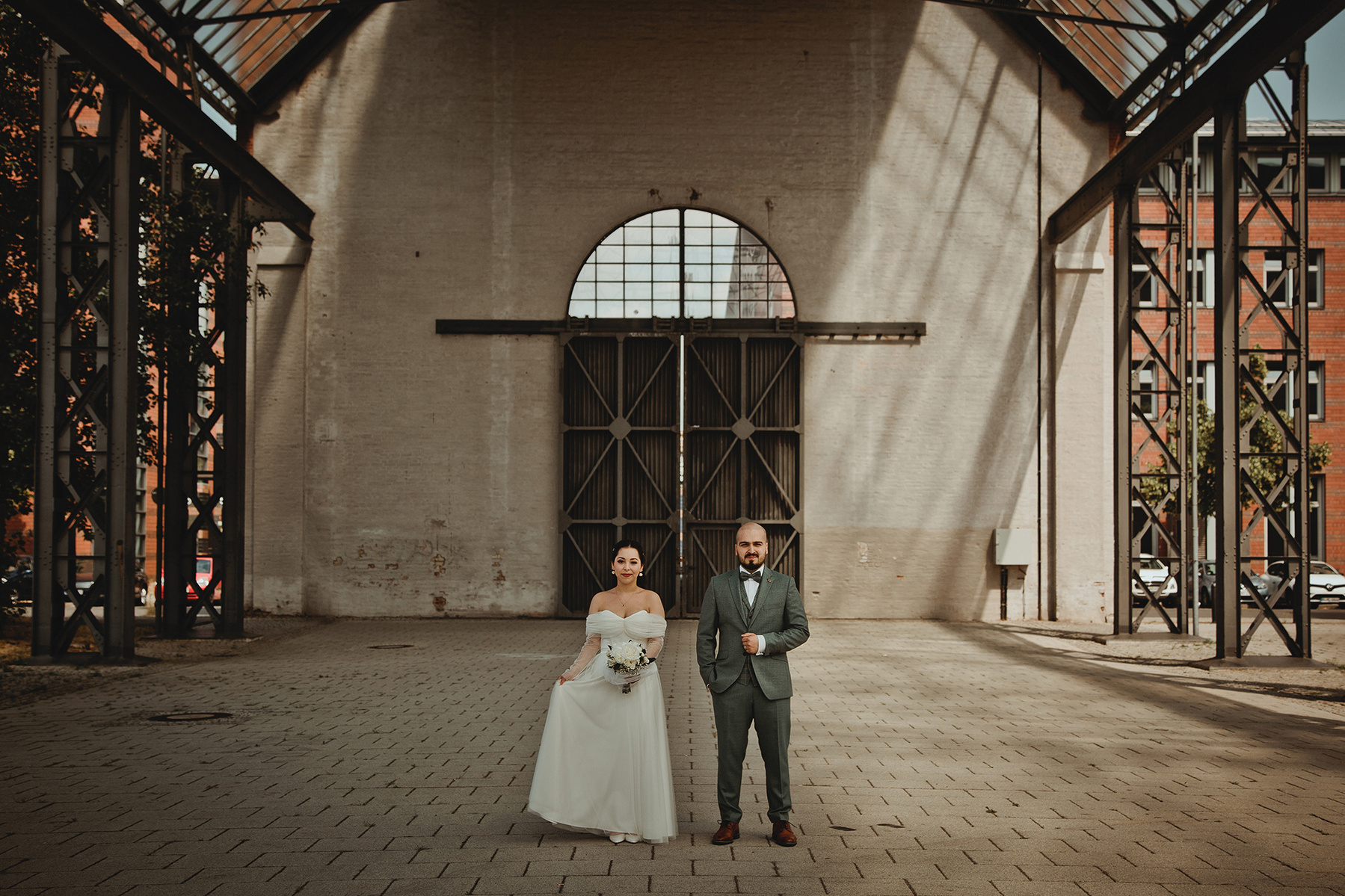 Besonderes Hochzeitsfoto von einem Brautpaar inmitten einer großen Halle im indutrial Style, aufgenommen von einer Hochzeitsfotografin in Berlin. 