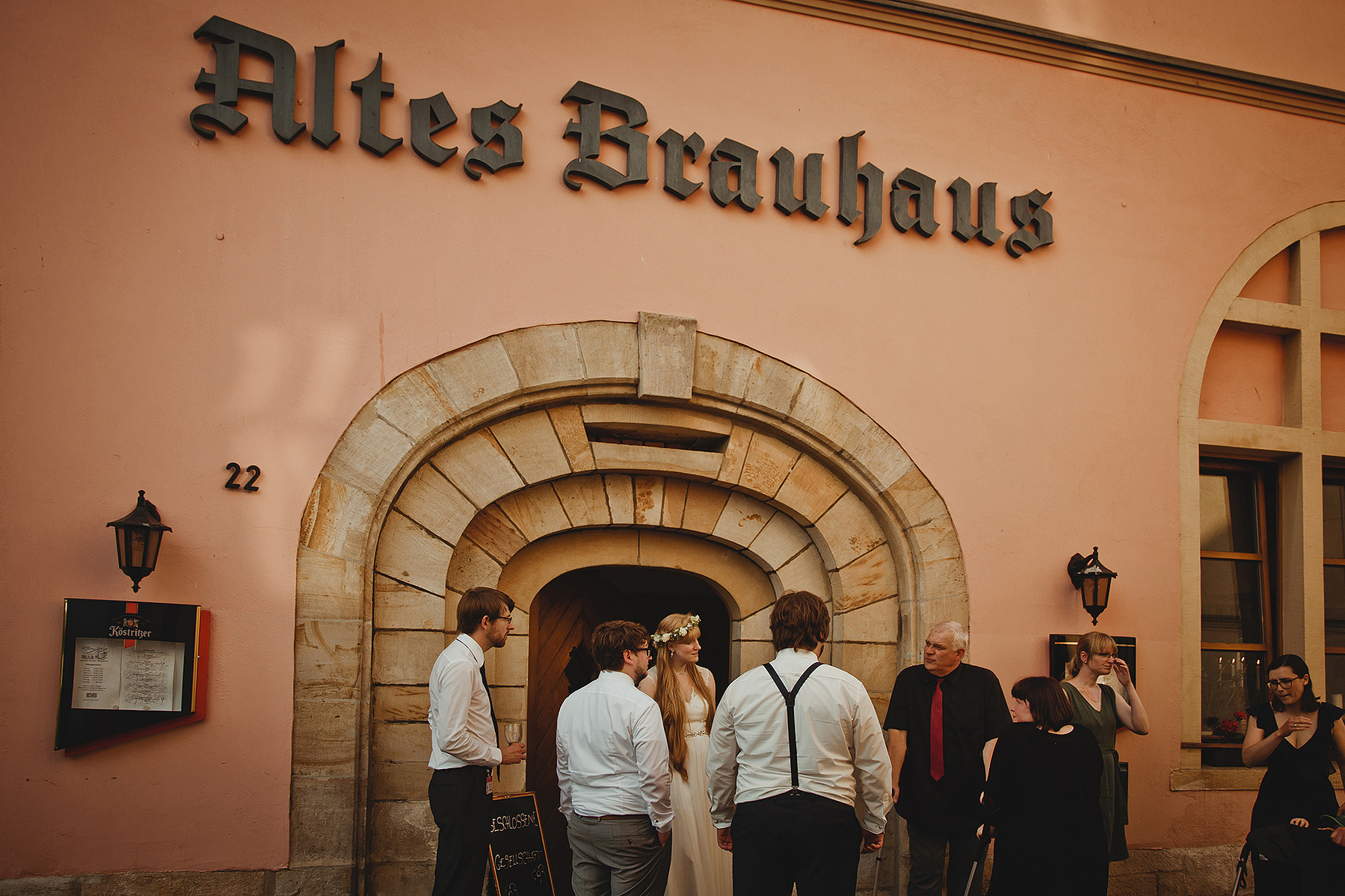 Der Bräutigam steht mit einigen Gästen vor der Hochzeitslocation Altes Brauhaus in Weißenfels.