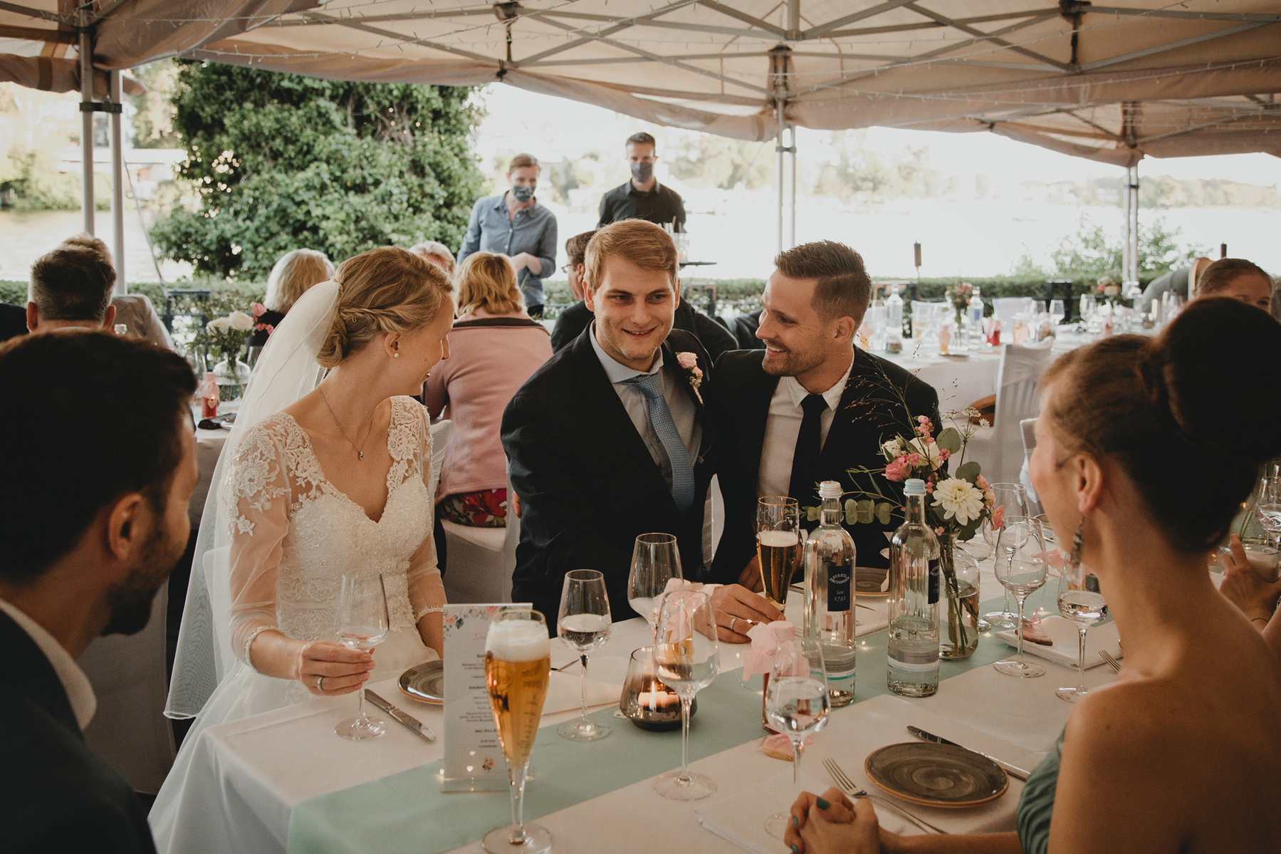 Das Brautpaar amüsiert sich mit den Hochzeitsgästen während der Feier im Schlosscafé Köpenick.