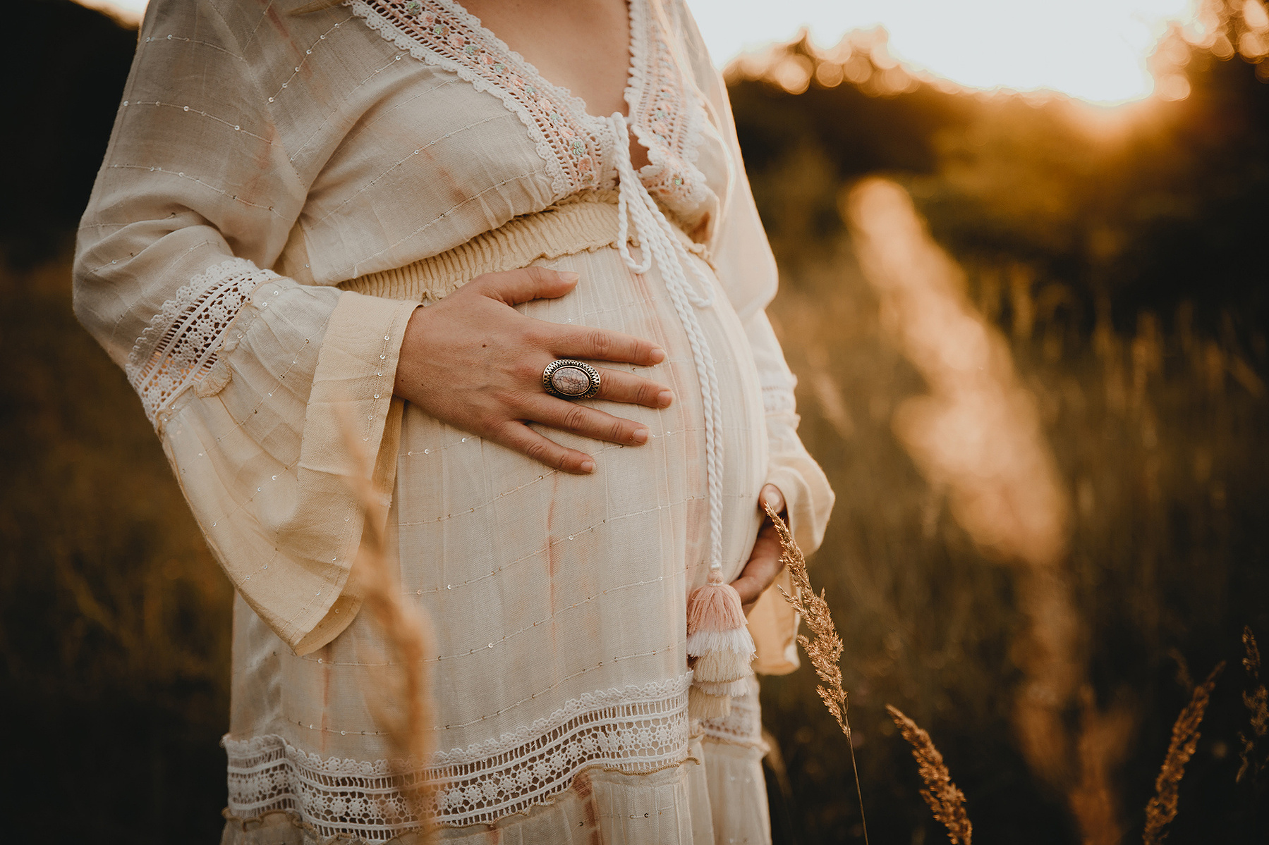 Bei einem boho Fotoshooting in Berlin streichelt Nathalie ihren Babybauch. 