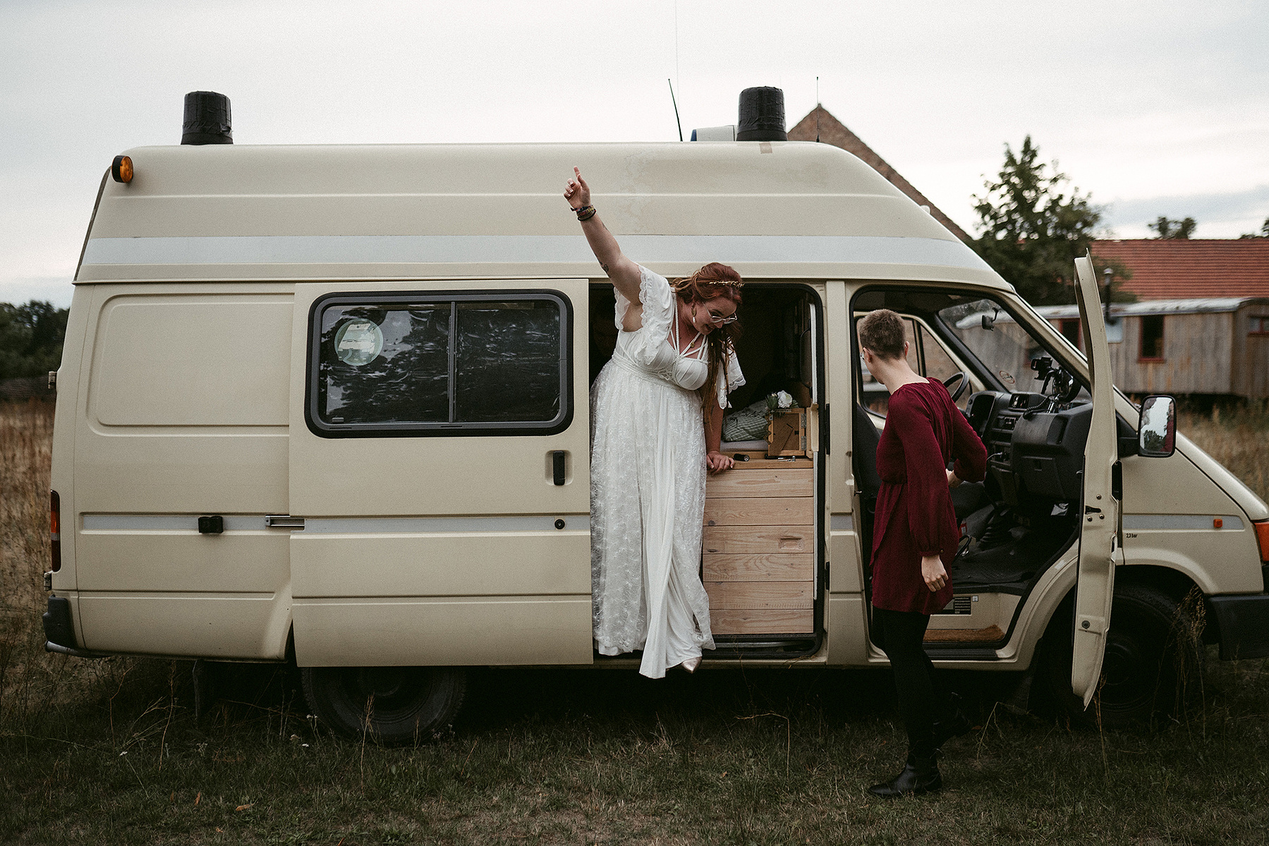 Die Braut steigt jubelnd aus einem Camping Van, nachdem sie das Escape Game gelöst hat.