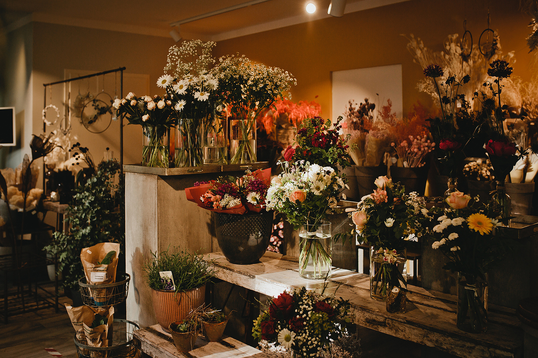 Innenaufnahme eines Blumengeschäfts in Berlin. Auf einem Regal stehen frische Blumensträuße. 