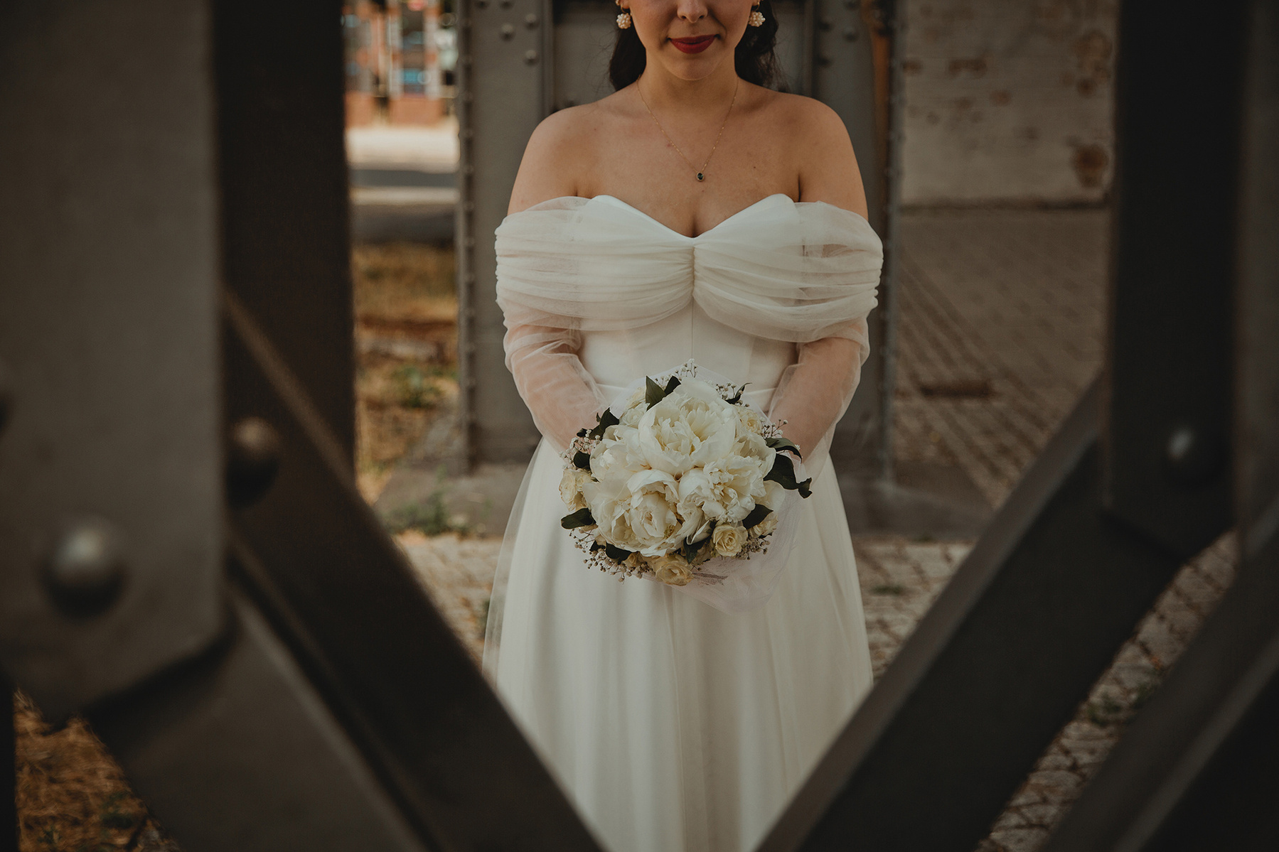 Detailaufnahme vom Brautstrauß mit weißen Pfingstrosen, gehalten von einer Braut im eleganten offshoulder Brautkleid. 