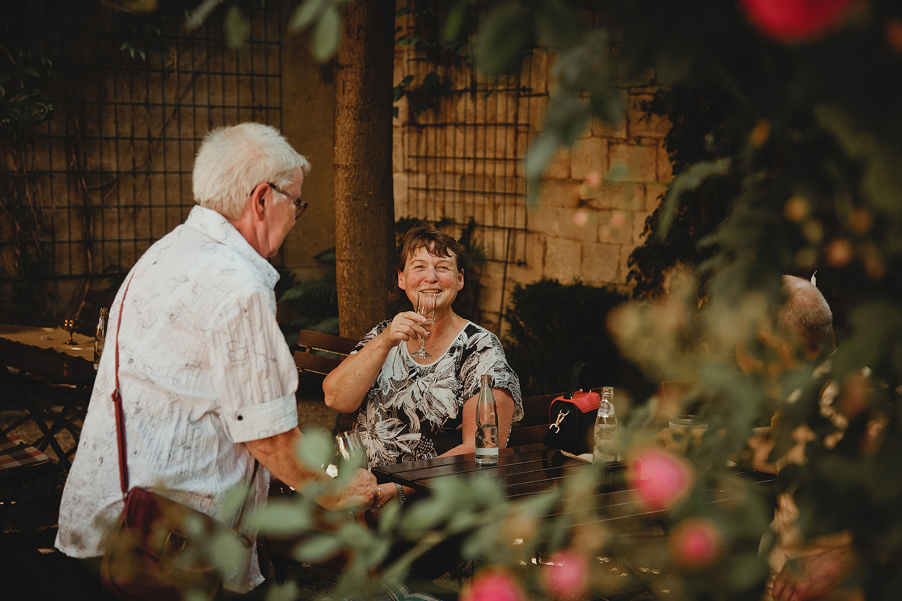 Ein Hochzeitsgast prostet während der Feier im Alten Brauhaus Weißenfels der Hochzeitsfotografin zu. 