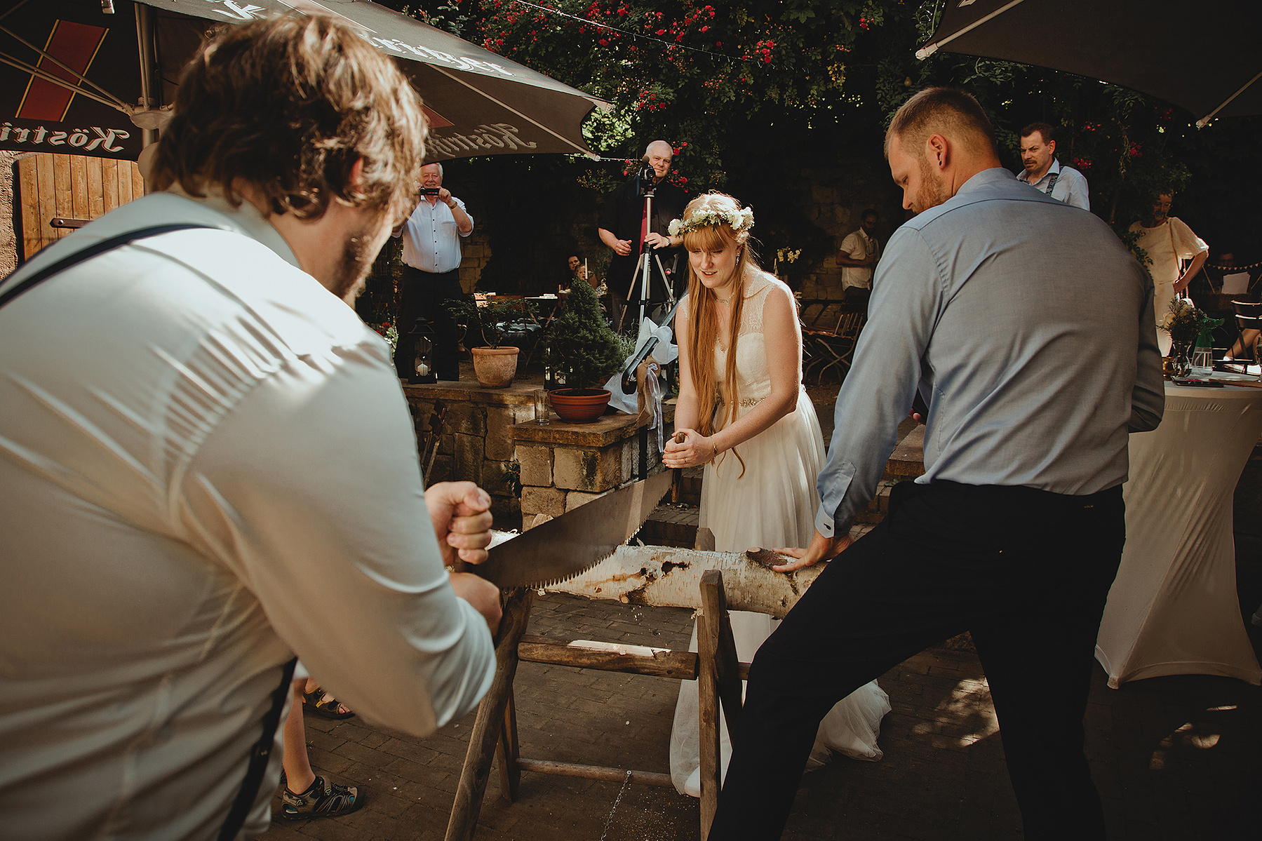 Das Brautpaar zersägt einen Baumstamm bei der Hochzeit in Weißenfels. 